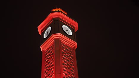 red illuminated clock tower at night