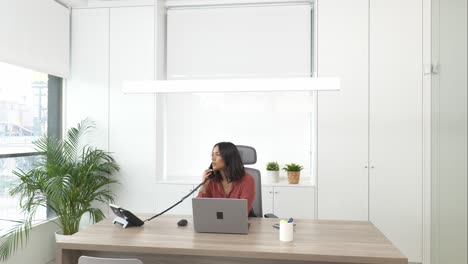 businesswoman answering a phone call in office