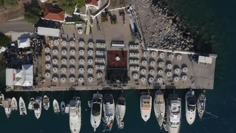 an aerial birds eye view of a wedding venue preparation in a pier in greece