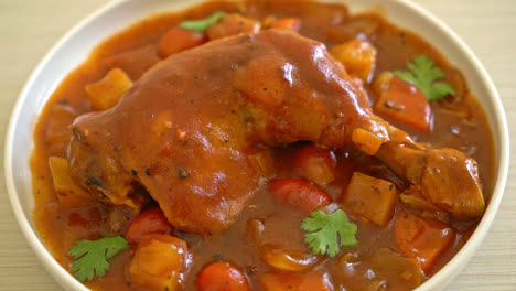 estofado de pollo casero con tomates, cebollas, zanahorias y patatas en el plato