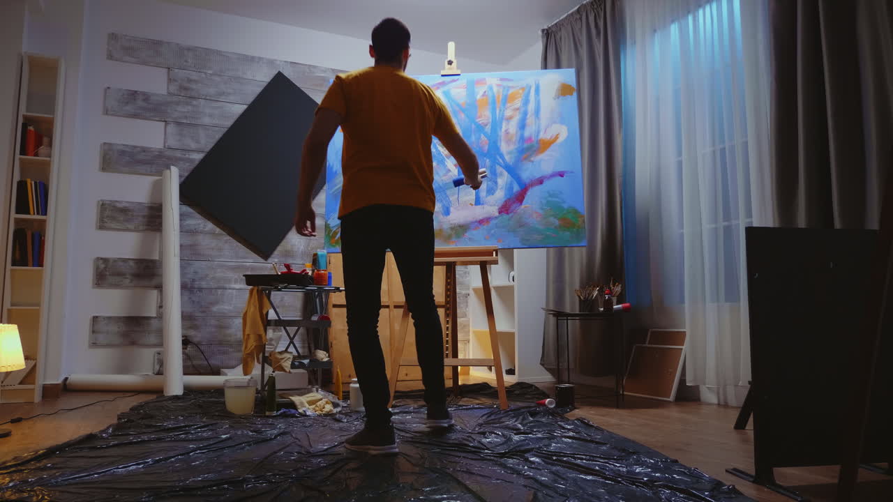 롤러로 캔버스에 그림을 그리는 남자