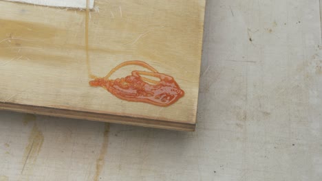 pouring polyester resin onto corner of plywood sheet