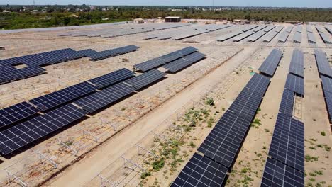 aerial tracking shot over unfinished sunlight collectors at a solar energy plant