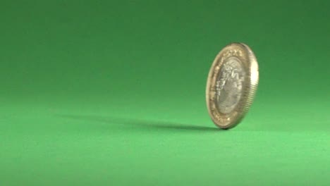 una moneda mexicana de 10 pesos girando sobre un fondo cromático