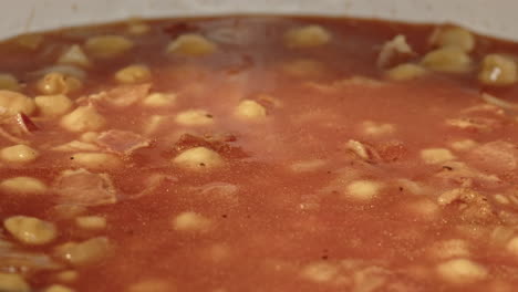 olive oil being poured in to a chick pea dish in slow motion macro