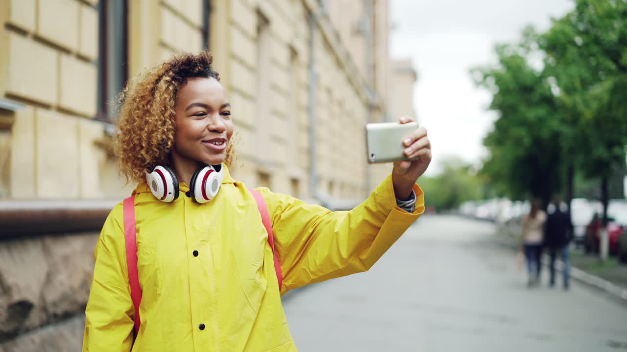 Young Woman Taking a Selfie Outdoors in a Rain Jacket
