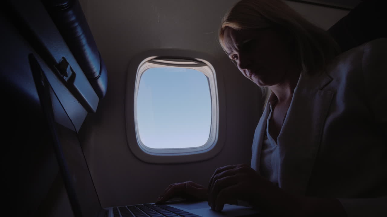 mujer de negocios usando laptop en vuelo
