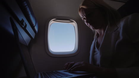 Business-Woman-Using-Laptop-In-Flight