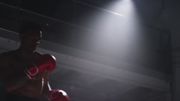 Close Up Shot Of Two Male Boxers Wearing Gloves In Boxing Ring Fighting In Boxing Match With Low Key Lighting 8