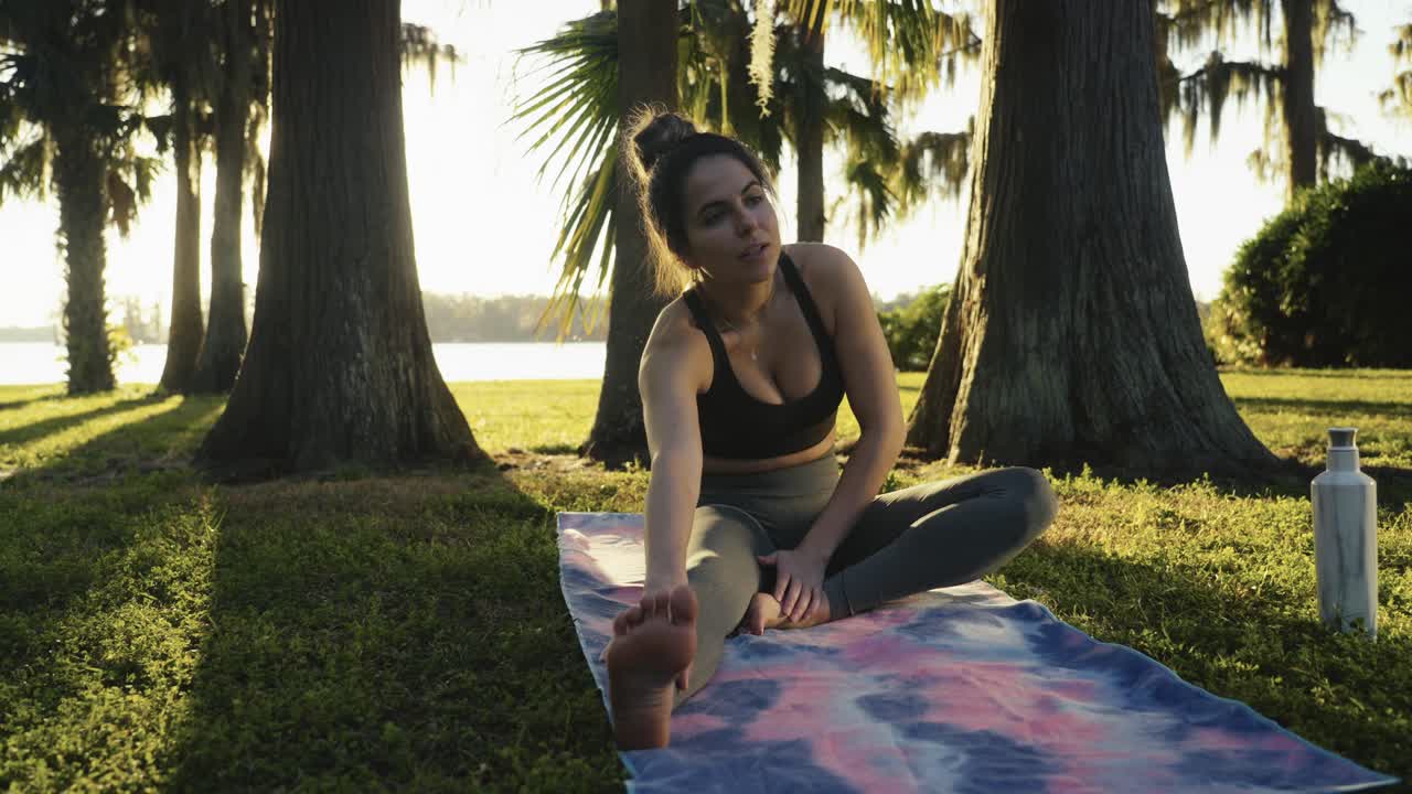 Bellissima giovane adulta che si sveglia per una sessione mattutina di yoga e stretching all'aperto