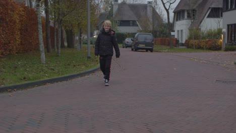 Angry-teenage-boy-walking-through-neighborhood-and-kicking-plastic-bottle