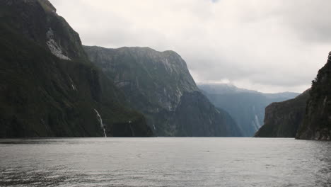 Explorando-Un-Majestuoso-Fiordo-Con-Cascadas-Y-Nubes-Amenazadoras