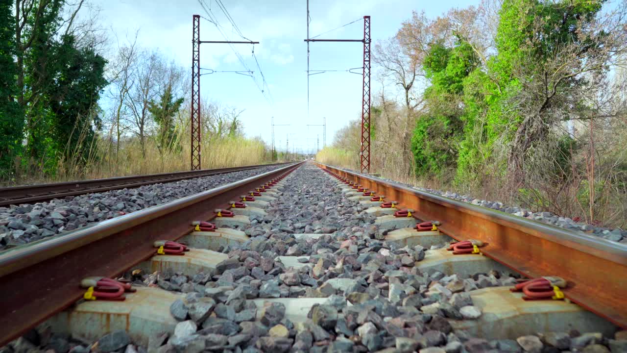 caminando en un ferrocarril en el campo, hermoso horizonte con cielo azul y nubes, punto de vista, símbolo de aventura