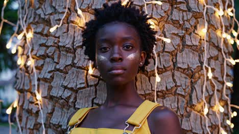 young woman with glitter makeup and yellow jumpsuit