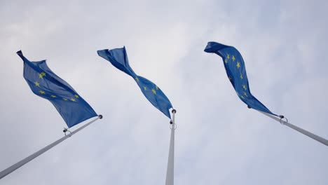 pov looking up european union flags in the wind at day - slow motion