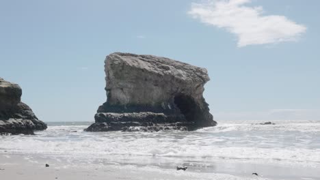 las olas del océano golpeando una gran roca