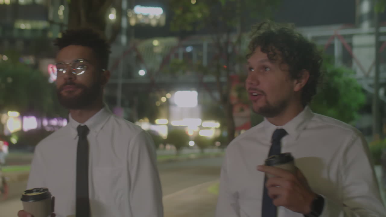Two Businessmen Having Coffee and Talking on Night Walk