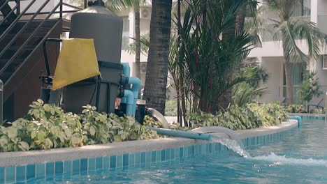 pump fills large hotel pool with water at resort slow motion