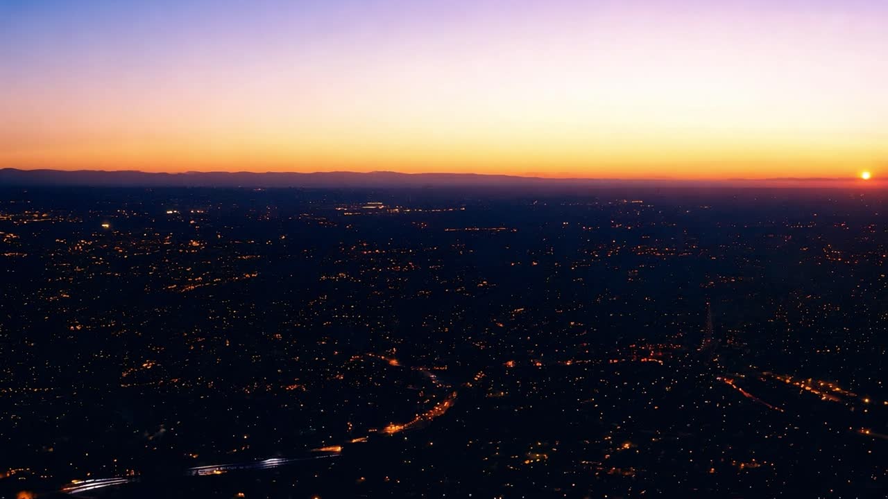 광활한 도시 위에서 해가 지는 것은 따뜻한 빛을 만들어 도시 풍경을 조명하고 스카이 라인의 아름다움을 강조합니다.