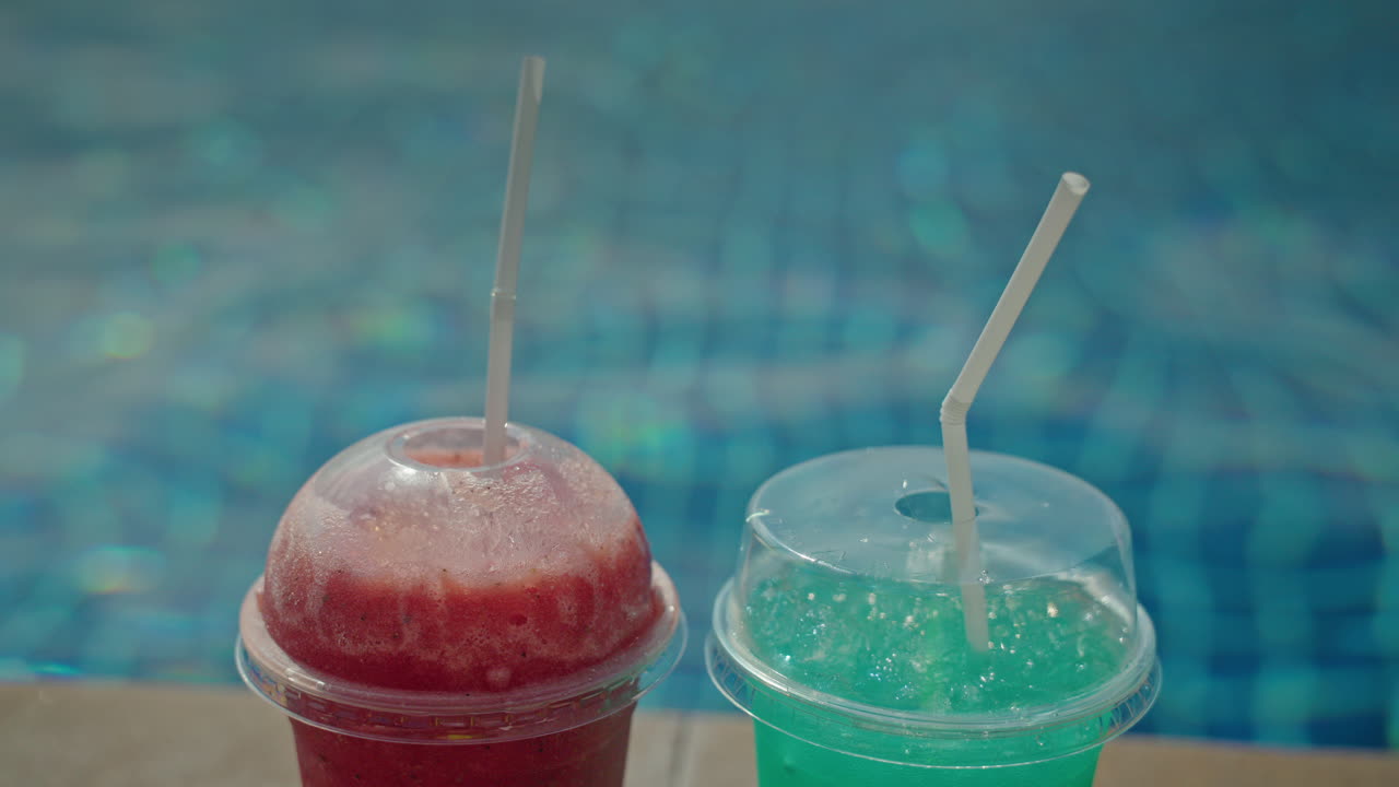 Two colorful frozen drinks by the pool