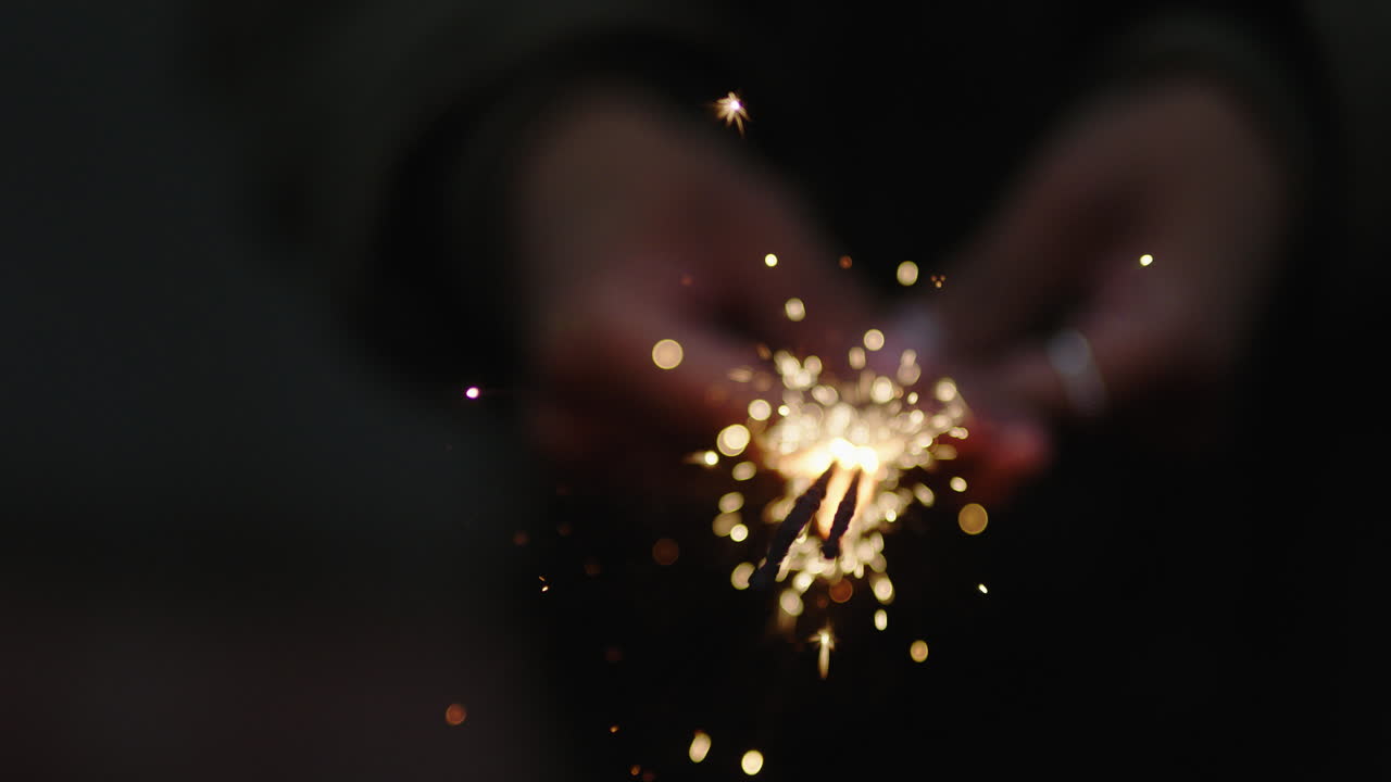 cerrar mujer bengala celebrando la celebración de nochevieja sosteniendo fuegos artificiales festivos en la noche
