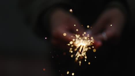 cerrar mujer bengala celebrando la celebración de nochevieja sosteniendo fuegos artificiales festivos en la noche