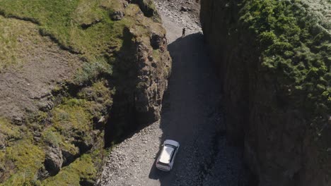 overhead view of a car driving through sheer canyons in westfjords, iceland