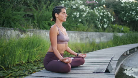 mujer deportiva practicando yoga en línea en un día de verano. mujer postura de loto meditación