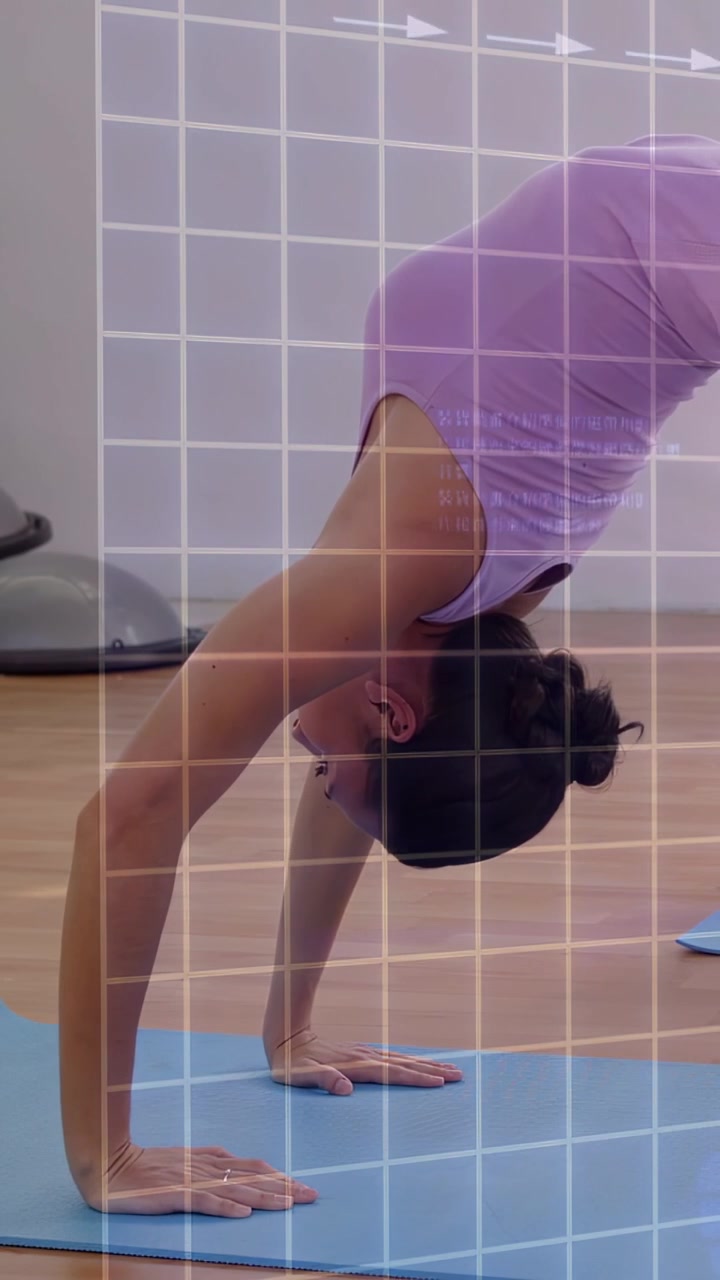 Vídeo vertical: Mulher abaixando as mãos, empurrando uma roda em tapete azul, com setas em grade guiando a prática de yoga
