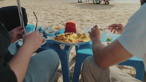 two tourists sharing seafood platter on brazilian beach, culinary travel and coastal lifestyle