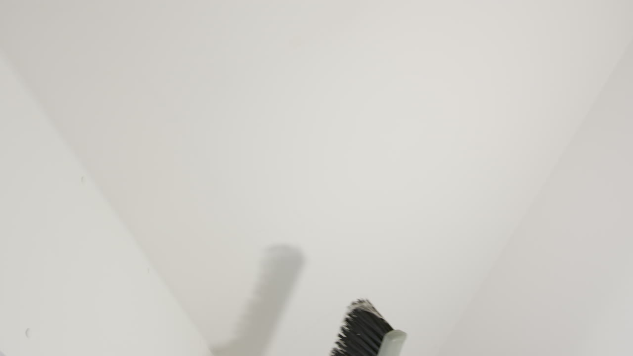 Cleaning cobwebs from ceiling of new apartment, dusty broom