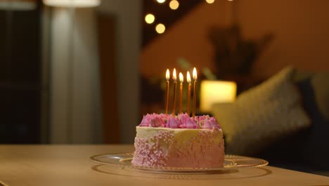 close up of party celebration cake for birthday decorated with icing and candles on table at home