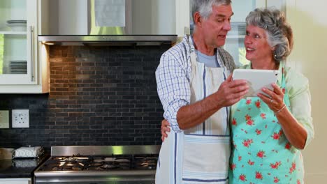 Senior-couple-using-digital-tablet-in-kitchen-4k