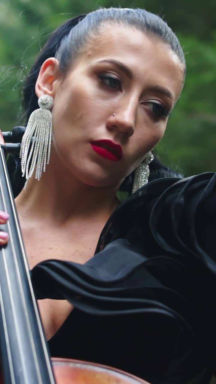 Girl performing music outdoor. Musician playing on cello on mountain nature