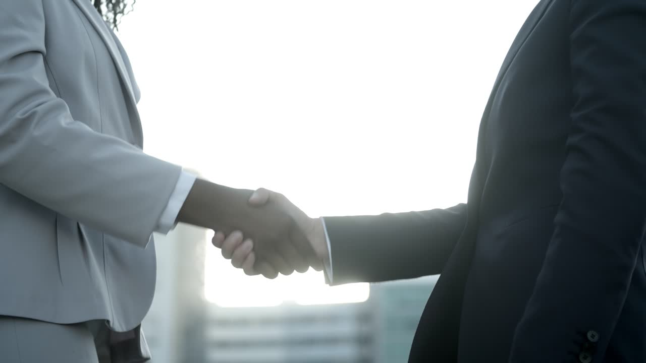 Business handshake on street against sunset