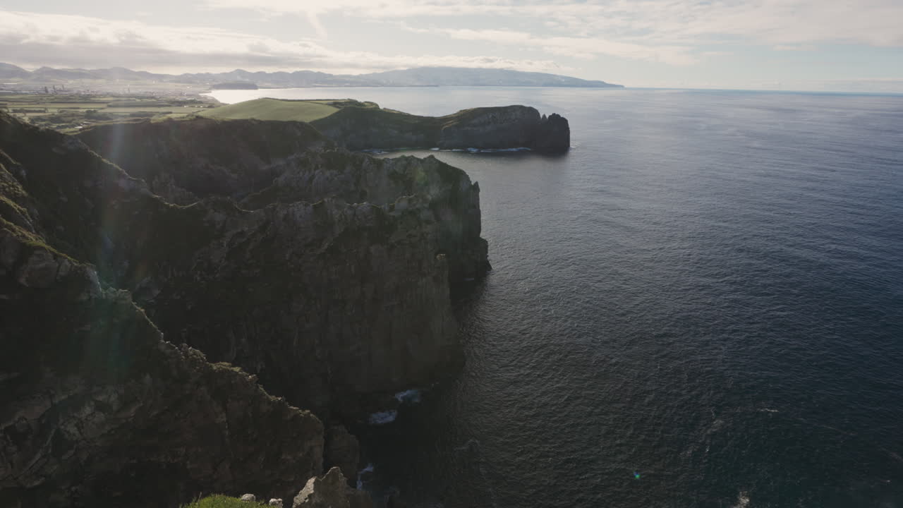 pov de excursionista mirando hacia arriba desde los zapatos hasta los acantilados junto al océano en las azores