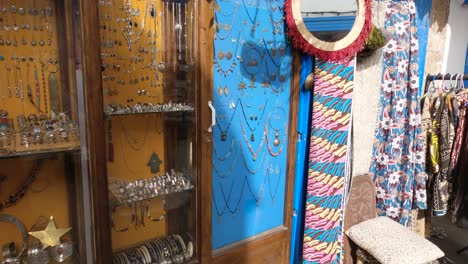 Pan-Up-View-Of-Local-Jeweller-Shop-Selling-Bracelets-And-Necklaces-In-Medina-quarter-in-Essaouira,-Morocco