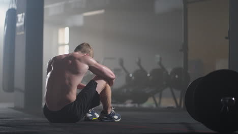 hombres jóvenes agotados descansando después de un entrenamiento intensivo en el gimnasio. fitness hombre saludable cansado después de un ejercicio de entrenamiento de fuerza en el gimnasio. hombre cansado modelo en forma con estar de pie y relajarse después de un entrenamiento intenso.