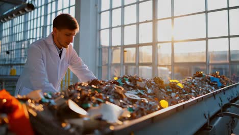 trabajador de una planta de reciclaje que inspecciona los materiales reciclados