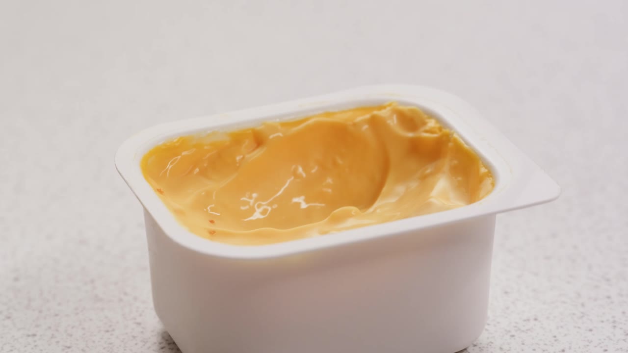 Intingere un anello di cipolla nella salsa al formaggio