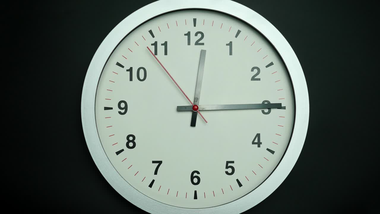 el reloj de pared blanco dice la hora del mediodía y 15 minutos.