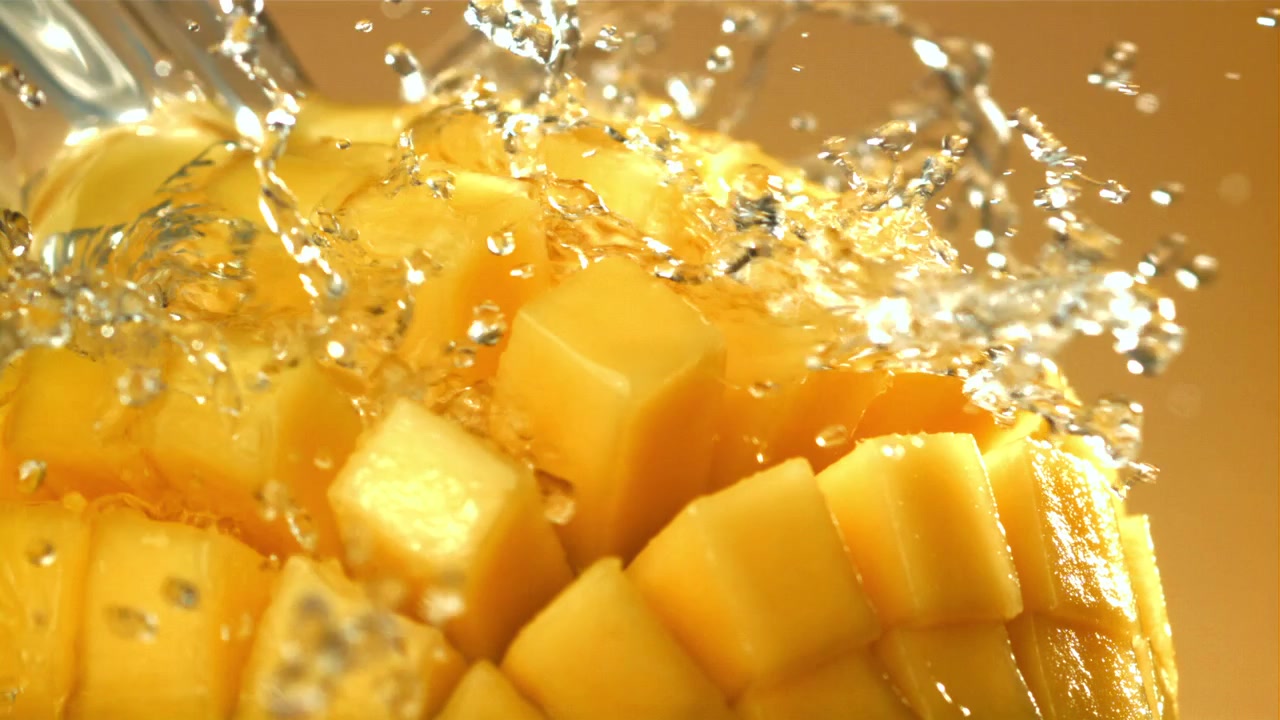 Schizzi d'acqua rinfrescanti su un succoso mango giallo