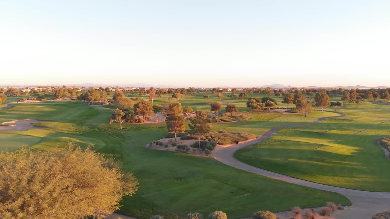 Drone footage from a golf course near a residential neighborhood in Arizona. High aerial shot of the greens