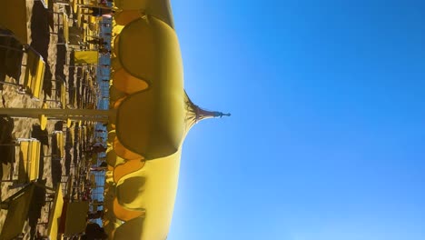 vertical slow motion shot of yellow umbrella on a beach near by the sea