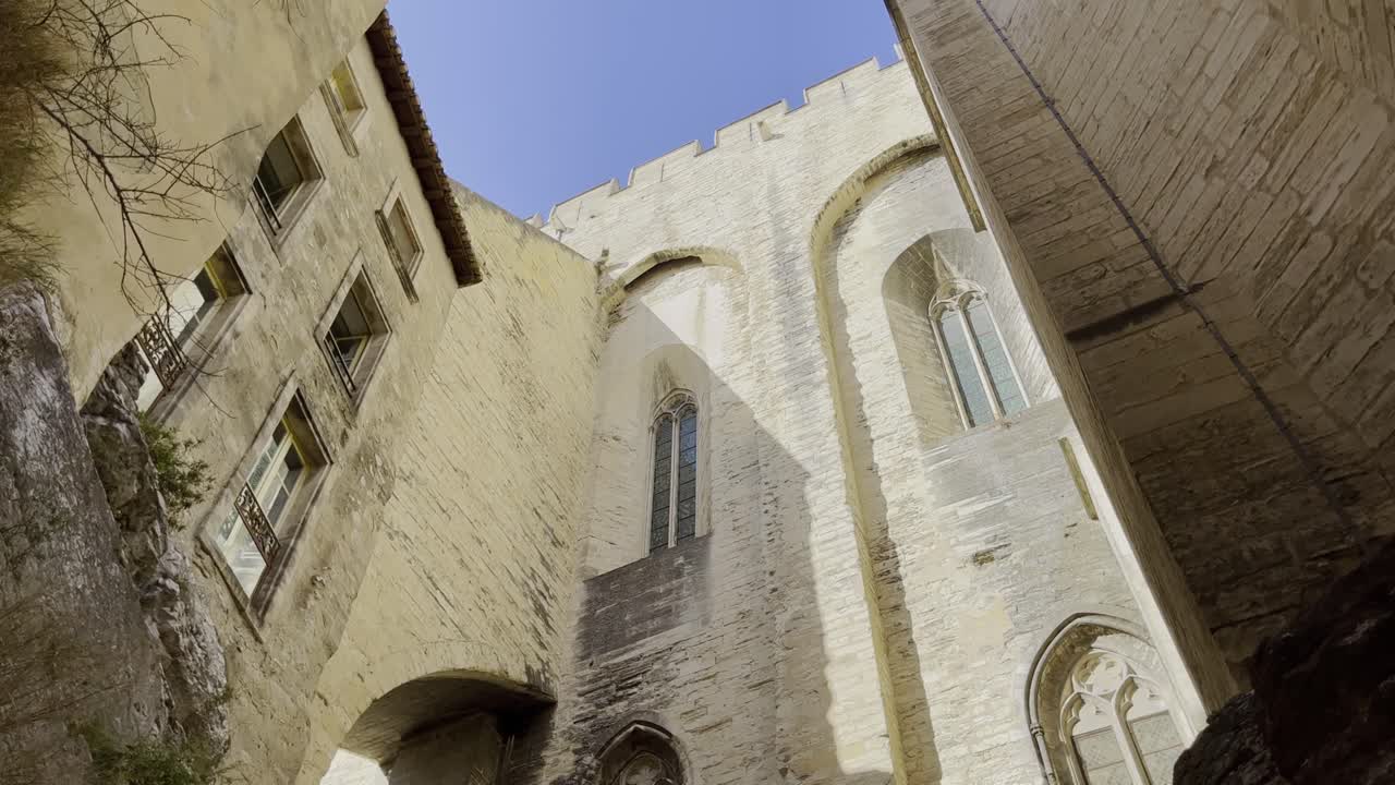 porche lateral alto de una iglesia en avignon hecho de piedra arenisca en buen tiempo con una pared al lado de ella
