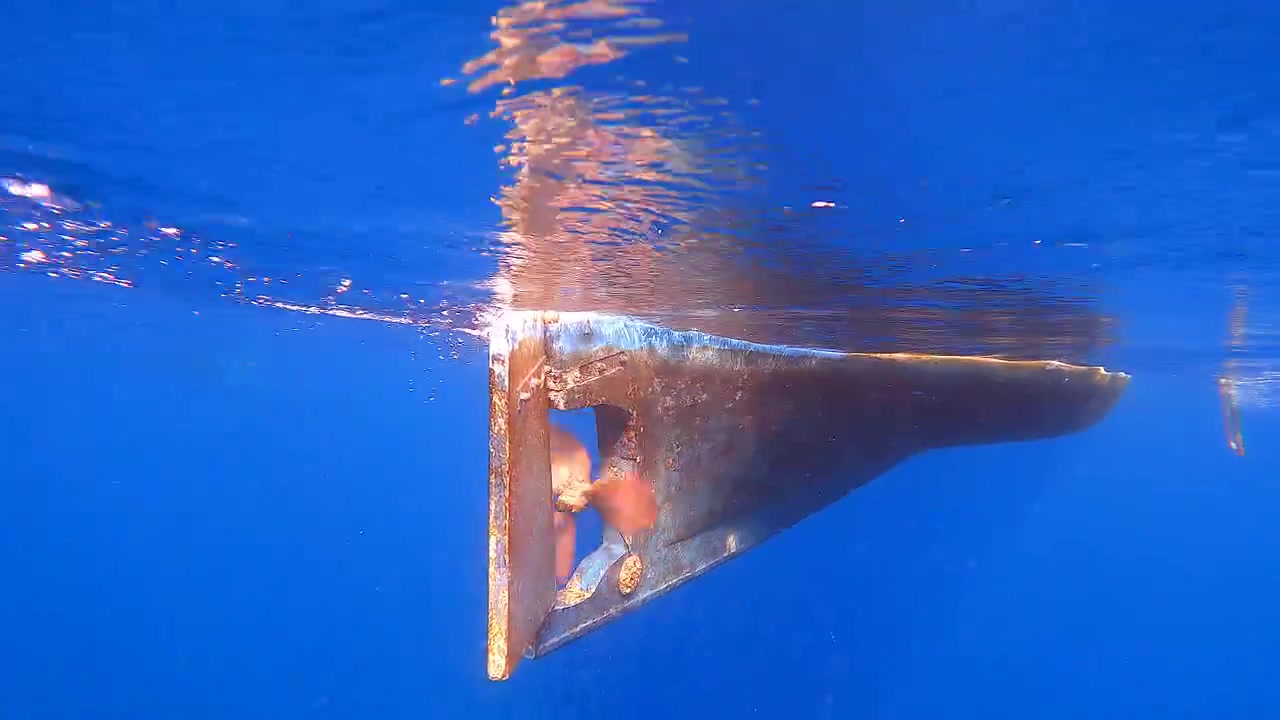 Underwater View of a Rotating Boat Propeller in Deep Blue Ocean