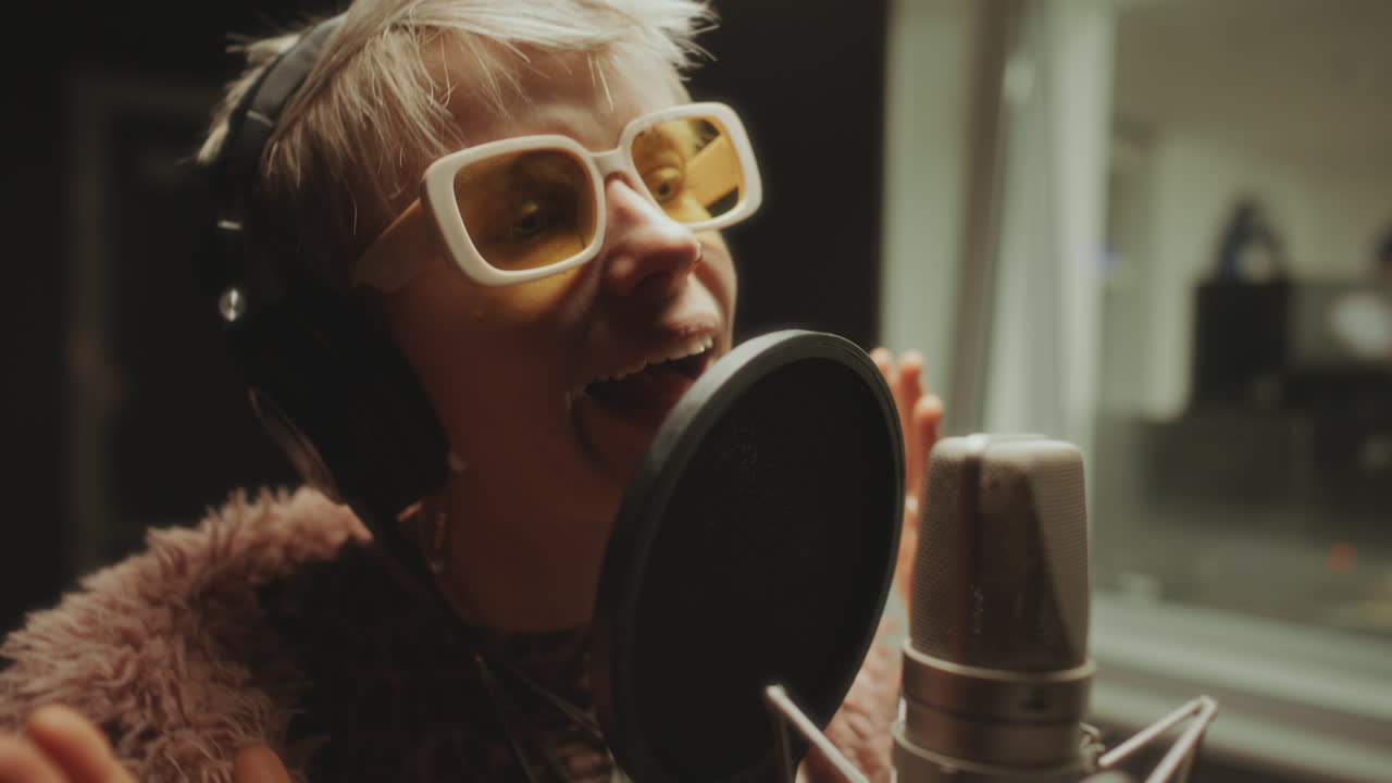 Female Vocalist Performing in Studio Booth with Professional Microphone