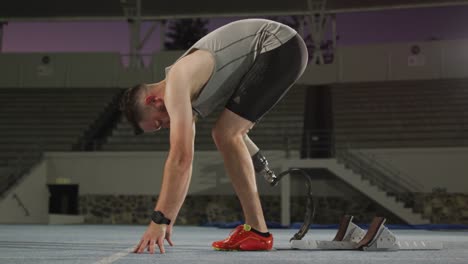 caucasian disabled male athlete with running blade getting ready to start a run