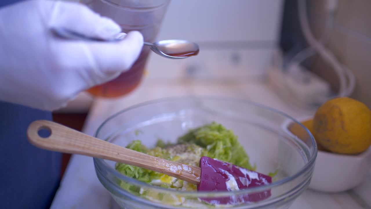 Close up on caucasian woman's hands wearing single use gloves, pouring vinegar in a bowl, preparing traditional greek, yoghurt based dip Tzatziki 4k