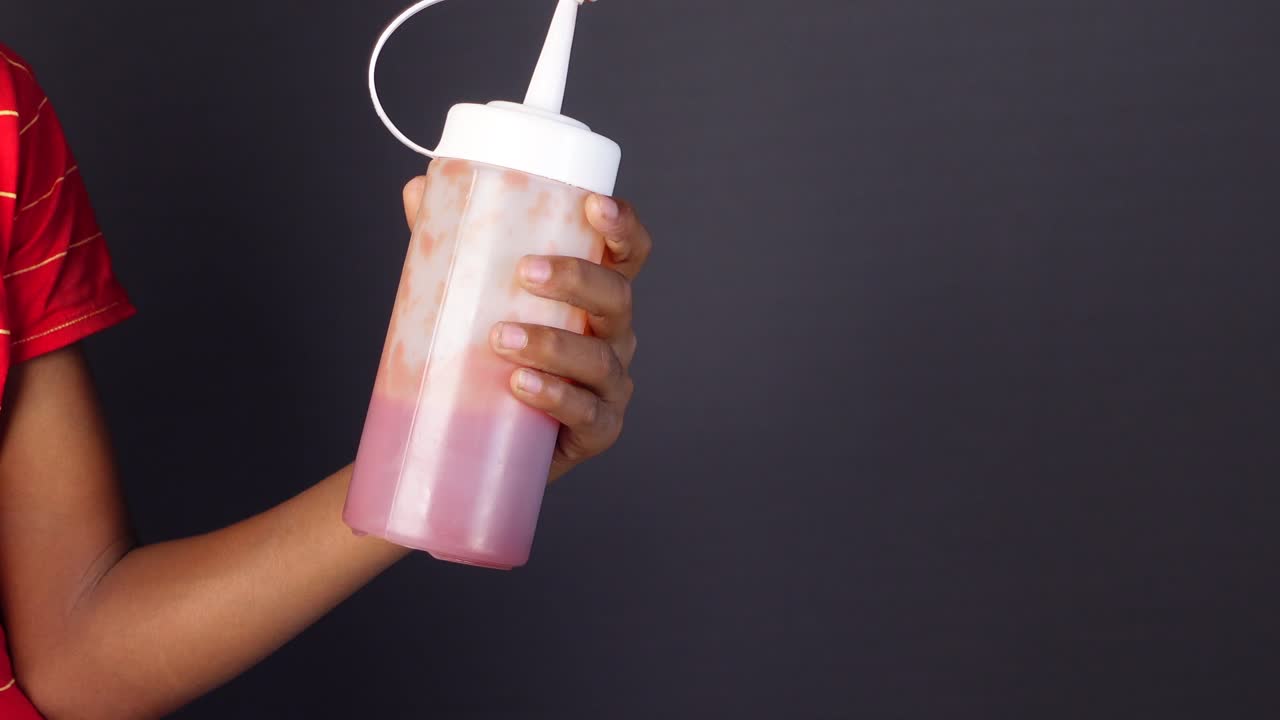 mano con una botella de salsa